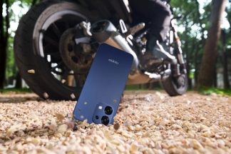 Smartphone OPPO A6 Pro scayendo a la arena desde una moto para certificar su resistencia